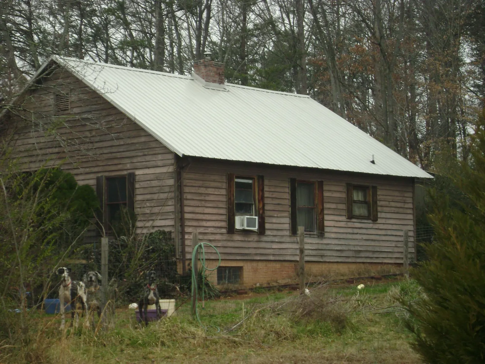 White metal roof on an old wood sided farmhouse, from a Metal Roof Installation job in Magnolia